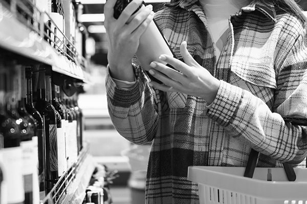 woman shopping in fully stocked wine section woman shopping in fully stocked wine section